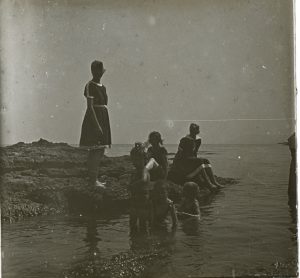 Retrat de cos sencer de tres dones de la família Bassols i els nens Dolors, Xavier i Joan Montsalvatge, a la platja, a Llançà.